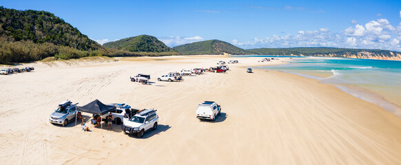 4WD vehicles and surfers at Double Island Point on a sunny day