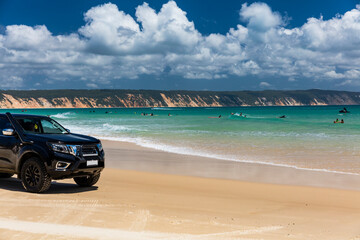 4WD vehicles and surfers at Double Island Point on a sunny day © Zstock