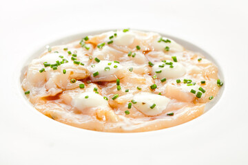 Delicious scallop ceviche with white sauce and green onion on white restaurant plate. Fish Peruvian seafood dish. Scallop ceviche, restaurant seafood plate. Healthy meal..