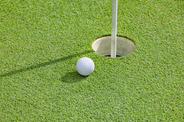 綺麗に手入れされたゴルフ場のグリーンと真っ白なゴルフボール