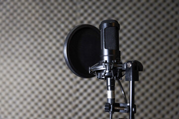 Microphones, condenser mic and mic stand with a recording studio background