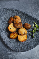 Roasted potato on dark restaurant plate. Vintage gray table. Gourmet food restaurant menu