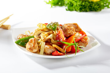 Udon noodles with sweet and sour chicken and vegetable. Asian style noodles food on white background. Udon in white plate with wooden choopsticks.