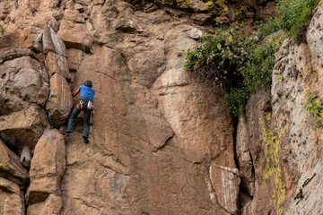 hombre fuerte escalando montaña 