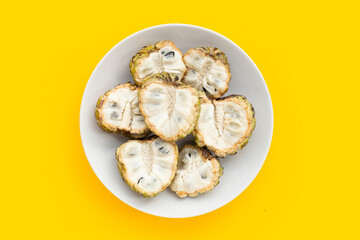 Custard apple in white plate on yellow background.