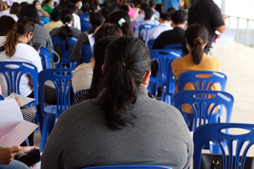 Filled with the back of a group of people waiting to be vaccinated against the COVID-19 virus.