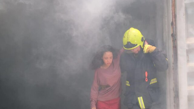 Fireman help to bring woman as victim out from smoked container room to safe her life from the dangerous.