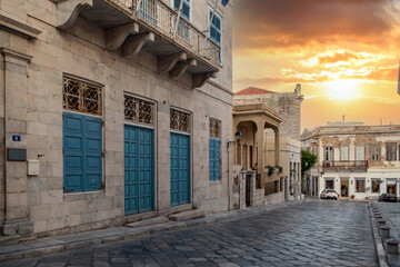 Syros island, Cyclades, Greece. Sunset over capital Hermoupolis buildings background.
