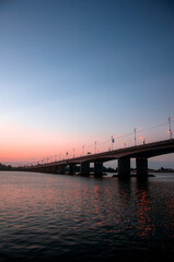 Fototapeta na wymiar bridge over the river with sunset background