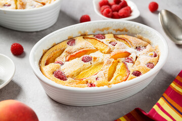 Traditional french pie clafoutis with fresh summer peaches and raspberry.