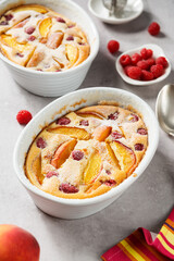 Traditional french pie clafoutis with fresh summer peaches and raspberry.