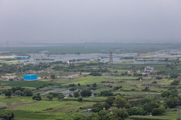 aerial landscape view of a developing city, outskirts of Delhi and Gurugram. Aerial View of Fields and towers.