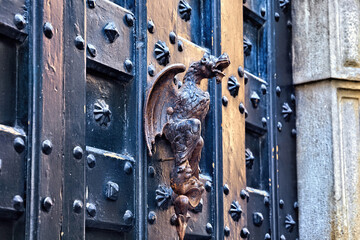 Doorhandle in the shape of a mythological creature as an element of an old vintage door