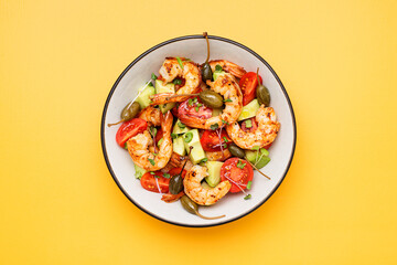 Easy grilled shrimp avocado salad with cherry tomatoes, capers and microgreens. Yellow background. Top view.	

