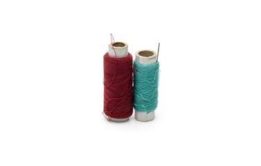 Two different color yarn threads spools on an isolated white background