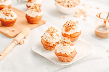 Muffin. Creme muffins with caramel and nuts. Creme on the top of muffin. Caramel muffins.  