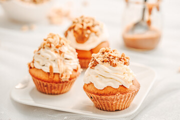 Muffin. Creme muffins with caramel and nuts. Creme on the top of muffin. Caramel muffins.  
