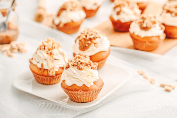 Muffin. Creme muffins with caramel and nuts. Creme on the top of muffin. Caramel muffins.  