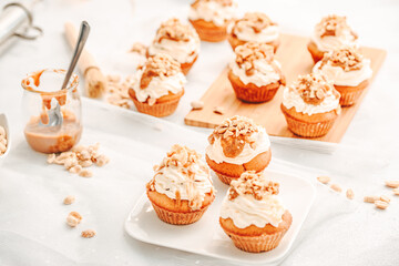 Muffin. Creme muffins with caramel and nuts. Creme on the top of muffin. Caramel muffins.  