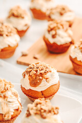 Muffin. Creme muffins with caramel and nuts. Creme on the top of muffin. Caramel muffins.  