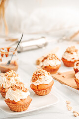 Muffin. Creme muffins with caramel and nuts. Creme on the top of muffin. Caramel muffins.  