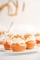Muffin. Creme muffins with caramel and nuts. Creme on the top of muffin. Caramel muffins.  