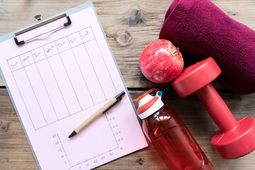 Personal workout plan with sneakers, smartphone and other fitness stuff.