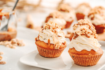 Muffin. Creme muffins with caramel and nuts. Creme on the top of muffin. Caramel muffins.  