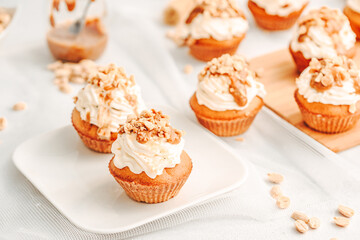 Muffin. Creme muffins with caramel and nuts. Creme on the top of muffin. Caramel muffins.  