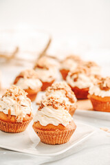 Muffin. Creme muffins with caramel and nuts. Creme on the top of muffin. Caramel muffins.  