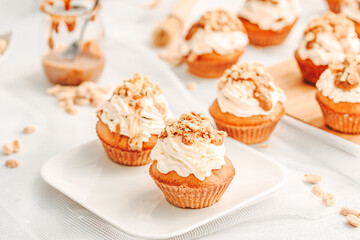 Muffin. Creme muffins with caramel and nuts. Creme on the top of muffin. Caramel muffins.  