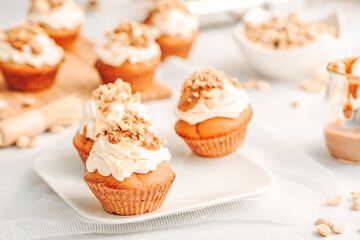 Muffin. Creme muffins with caramel and nuts. Creme on the top of muffin. Caramel muffins.  