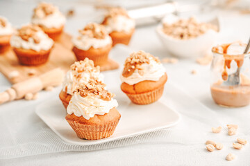 Muffin. Creme muffins with caramel and nuts. Creme on the top of muffin. Caramel muffins.  