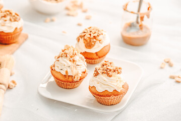 Muffin. Creme muffins with caramel and nuts. Creme on the top of muffin. Caramel muffins.  