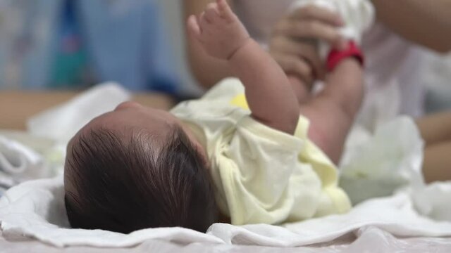 Select focus baby boy at bed. Mother clean the poop and wrap the diaper