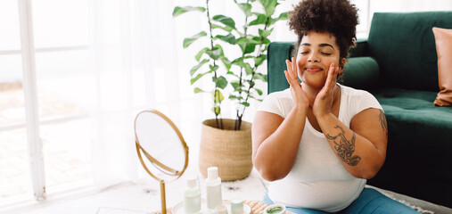Woman applying facial cream at home