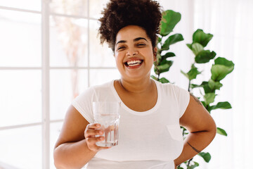 Healthy woman with glass of water at home - Powered by Adobe