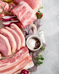 Assortment of raw pork meat on light grey background. Organic gourmet food concept.