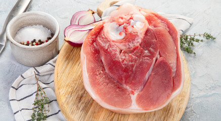 Raw ham leg on ligth gray background. Organic gourmet food concept.