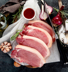 Sliced raw pork meat on dark gray background. Organic gourmet food concept.