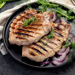 Sliced roasted pork meat on dark gray background. Organic gourmet food concept.
