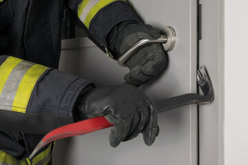 the fireman's hands open the closed door with a special tool