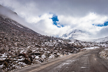 isolated tarmac road with snow cap mountain background and amazing sky at morning