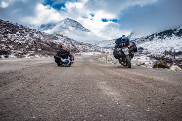 man solo traveler at isolated tarmac road with snow cap mountains in background at morning