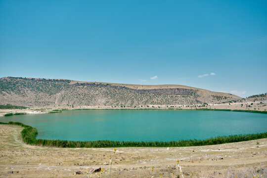 Magnificent blue sky and turquoise color lake of Narli Gol Crater and geothermal field covered by many hills.