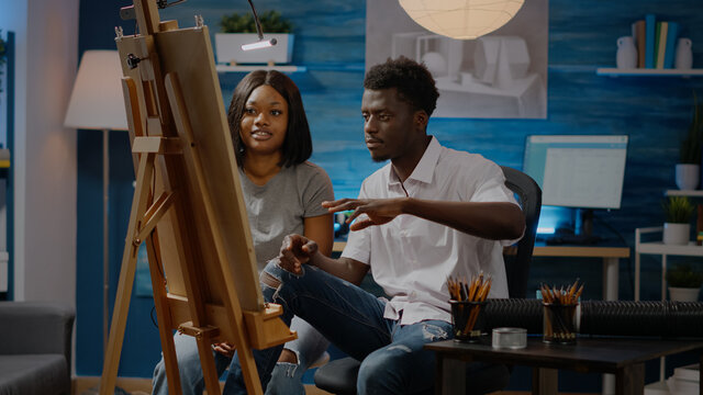 African american young people working on canvas for drawing at art studio. Black artists using tools and pencil for masterpiece project and fine art concept. Creative adult couple