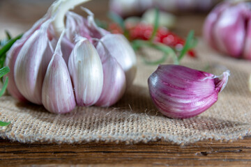 garlic bulbs and cloves arranged on an old board.
