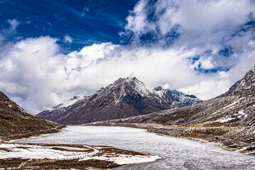 snow cap mountains with frozen lake and bright blue sky at morning from flat angle