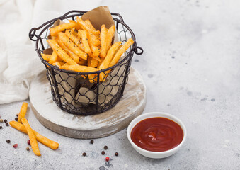 French fries chips in snack bucket with tomato ketchup and pepper on light background.
