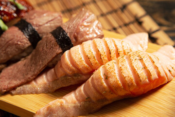 Beef sushi and salmon sushi on a bamboo plate 
